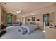 Spacious main bedroom featuring a sitting area, a ceiling fan, and views of lush greenery at 35180 N Boulder Pass, Scottsdale, AZ 85266