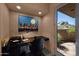 Bright office space with sleek black desk, vibrant art, and a door leading to an outdoor patio at 35180 N Boulder Pass, Scottsdale, AZ 85266