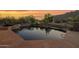 Backyard pool with stone trim, lush desert plants, and desert mountain views at 35180 N Boulder Pass, Scottsdale, AZ 85266