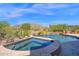 Luxurious pool and spa area with desert landscaping, offering relaxation and stunning views of the surrounding mountains at 35180 N Boulder Pass, Scottsdale, AZ 85266