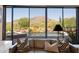 Living room view showcases a private pool and scenic mountain backdrop through expansive glass doors at 35180 N Boulder Pass, Scottsdale, AZ 85266