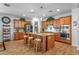Well-lit kitchen with a large central island, wooden cabinets, granite countertops, and stainless appliances at 3634 E Perkinsville St, Gilbert, AZ 85295