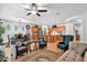 Open-concept living room and kitchen with wood floors, ceiling fan, and breakfast bar at 3634 E Perkinsville St, Gilbert, AZ 85295
