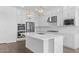 Bright kitchen features a large island, white cabinetry, and modern stainless steel appliances at 37735 W Santa Maria St, Maricopa, AZ 85138