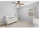 Neutral bedroom featuring a ceiling fan, large window, and a crib at 3818 E Appaloosa Rd, Gilbert, AZ 85296