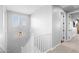Bright hallway with white railing leading upstairs with large window and a modern light fixture at 3818 E Appaloosa Rd, Gilbert, AZ 85296