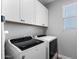 A modern laundry room with white cabinets, stainless steel appliances, and a bright window at 3818 E Appaloosa Rd, Gilbert, AZ 85296