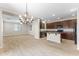 Open-concept kitchen and dining area with brown cabinetry, tile flooring, and modern lighting at 3837 E Santa Fe Ln, Gilbert, AZ 85297