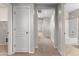 Hallway with neutral colors and doorways leading to various rooms, including a bathroom with a tub-shower combo at 3837 E Santa Fe Ln, Gilbert, AZ 85297