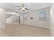 Spacious living room featuring tile floors, a ceiling fan, large windows, and a sliding glass door at 3837 E Santa Fe Ln, Gilbert, AZ 85297