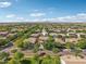 Aerial photo of a home in a neighborhood filled with mature trees. Mountains can be seen in the distance at 4109 E Sierra Madre Ave, Gilbert, AZ 85296