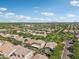 Aerial view captures a neighborhood with well-maintained homes, mature trees, and clear blue skies in the distance at 4109 E Sierra Madre Ave, Gilbert, AZ 85296