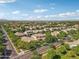 An aerial view of a neighborhood with many mature trees. Mountains are visible in the background at 4109 E Sierra Madre Ave, Gilbert, AZ 85296