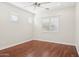 Cozy bedroom featuring hardwood flooring, a ceiling fan, and bright windows at 4109 E Sierra Madre Ave, Gilbert, AZ 85296
