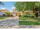 Charming two-story home with a paver driveway, mature trees, and well-maintained landscaping at 4109 E Sierra Madre Ave, Gilbert, AZ 85296
