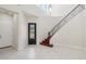 Bright foyer featuring a grand staircase, soaring ceilings, tile flooring, and a decorative front door at 4109 E Sierra Madre Ave, Gilbert, AZ 85296