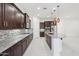 Spacious kitchen with dark wood cabinets, granite countertops, stainless steel appliances and tiled floor at 4109 E Sierra Madre Ave, Gilbert, AZ 85296