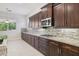 Stylish kitchen showcasing dark wood cabinetry, granite countertops, and modern appliances at 4109 E Sierra Madre Ave, Gilbert, AZ 85296