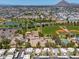 An aerial capture features residential areas with sports amenities, a lake, and mountain views against a clear sky at 4228 N 81St St, Scottsdale, AZ 85251