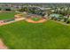 Drone view of the baseball field with manicured landscaping, sports lighting, and mature trees at 4228 N 81St St, Scottsdale, AZ 85251