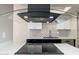 Close-up of the kitchen featuring sleek black vent hood, modern backsplash, and stainless steel appliances at 4228 N 81St St, Scottsdale, AZ 85251