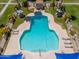 Aerial view of a large outdoor pool surrounded by lounge chairs, tables with umbrellas, and beautifully landscaped greenery at 4228 N 81St St, Scottsdale, AZ 85251