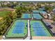 Aerial view of blue tennis courts with a player visible on one court, showcasing the sports facilities at 4228 N 81St St, Scottsdale, AZ 85251