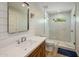 Bright bathroom features modern sink, wood cabinet, and a walk-in shower with glass door at 502 W Port Royale Ln, Phoenix, AZ 85023