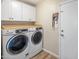Laundry room with front loading washer and dryer, butcher block countertop, and white cabinets at 502 W Port Royale Ln, Phoenix, AZ 85023
