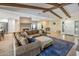 Spacious living room featuring exposed beam ceiling and open layout to kitchen and dining areas at 502 W Port Royale Ln, Phoenix, AZ 85023