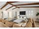 Inviting living room featuring exposed beam ceiling, comfortable sofa and large screen TV at 502 W Port Royale Ln, Phoenix, AZ 85023