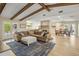 Open-concept living room with exposed beam ceiling, brick fireplace, and view into the bright kitchen at 502 W Port Royale Ln, Phoenix, AZ 85023