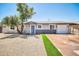 The house features a blue door and white garage, complemented by a landscaped front yard with gravel and artificial turf at 5236 S 19Th Ave, Phoenix, AZ 85041
