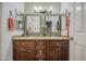 Bathroom featuring a dual sink vanity with granite countertops and decorative mirrors at 5424 E Florian Ave, Mesa, AZ 85206