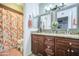 Bathroom with a dual sink vanity with granite countertops and a shower with an orange patterned curtain at 5424 E Florian Ave, Mesa, AZ 85206