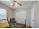Cozy bedroom featuring a ceiling fan, closet, a green chair, and natural light through window at 5424 E Florian Ave, Mesa, AZ 85206