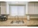 Modern kitchen sink area features granite countertops, stainless sink, and white cabinetry at 5424 E Florian Ave, Mesa, AZ 85206