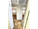 Hallway with tiled flooring leading to two bedrooms with wood laminate flooring and natural light at 5749 S 247Th Dr, Buckeye, AZ 85326