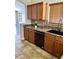 Updated kitchen with brown cabinetry, a tiled backsplash, and modern black appliances at 5749 S 247Th Dr, Buckeye, AZ 85326