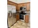 Modern kitchen featuring stainless steel appliances, a refrigerator, and a gas range for cooking at 5749 S 247Th Dr, Buckeye, AZ 85326
