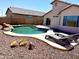 Resort style backyard with sparkling pool, decorative rock, lounge chairs and low maintenance landscaping at 5749 S 247Th Dr, Buckeye, AZ 85326
