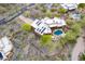 Expansive aerial view of desert home with pool, outdoor seating, and solar panels on white roof at 5892 E Carefree Mountain Dr, Carefree, AZ 85377