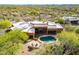 Tranquil backyard with blue pool surrounded by lush trees and a stone patio with comfortable seating at 5892 E Carefree Mountain Dr, Carefree, AZ 85377