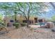 A serene backyard offers a tranquil retreat with desert landscaping and an outdoor fireplace and pool area at 5892 E Carefree Mountain Dr, Carefree, AZ 85377