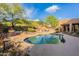 The lush backyard features a pool, a comfortable seating area, and desert views at 5892 E Carefree Mountain Dr, Carefree, AZ 85377