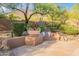 A serene outdoor seating area offers a peaceful desert landscape with built-in bench and lush greenery at 5892 E Carefree Mountain Dr, Carefree, AZ 85377