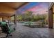 Spacious backyard featuring a covered patio, pool, and lush desert landscaping at 5892 E Carefree Mountain Dr, Carefree, AZ 85377