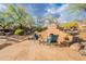 Inviting outdoor space featuring a built-in fireplace, comfortable seating, and desert landscaping at 5892 E Carefree Mountain Dr, Carefree, AZ 85377