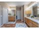 Dual sink bathroom featuring decorative rugs, tiled floors, and wooden vanities at 5892 E Carefree Mountain Dr, Carefree, AZ 85377