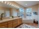 Bright bathroom with tiled countertops, a large mirror, and a jetted soaking tub by the window at 5892 E Carefree Mountain Dr, Carefree, AZ 85377